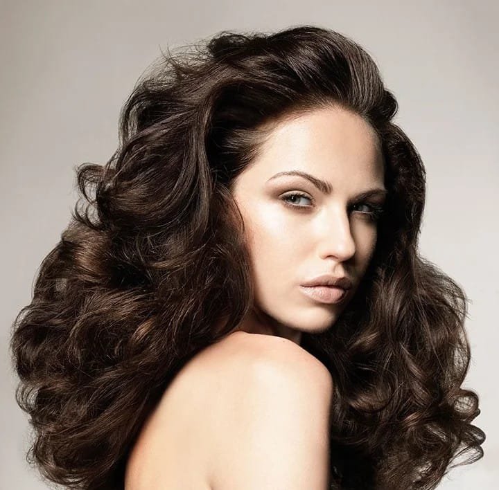 Beautiful woman with shiny healthy hair after following dry and damaged hair care routine