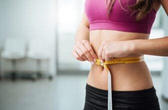 Woman measuring waist during healthy weight loss after 40 journey