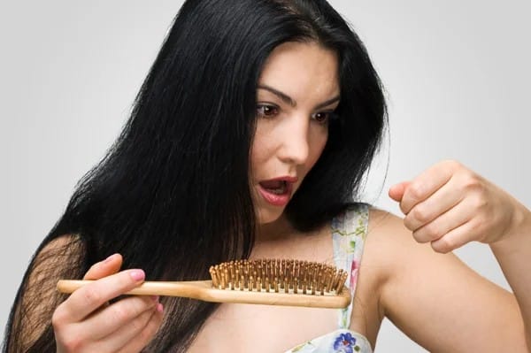 Woman worried about hair loss while washing hair in the shower