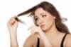 Woman checking damaged strands while learning how to take care of dry hair naturally